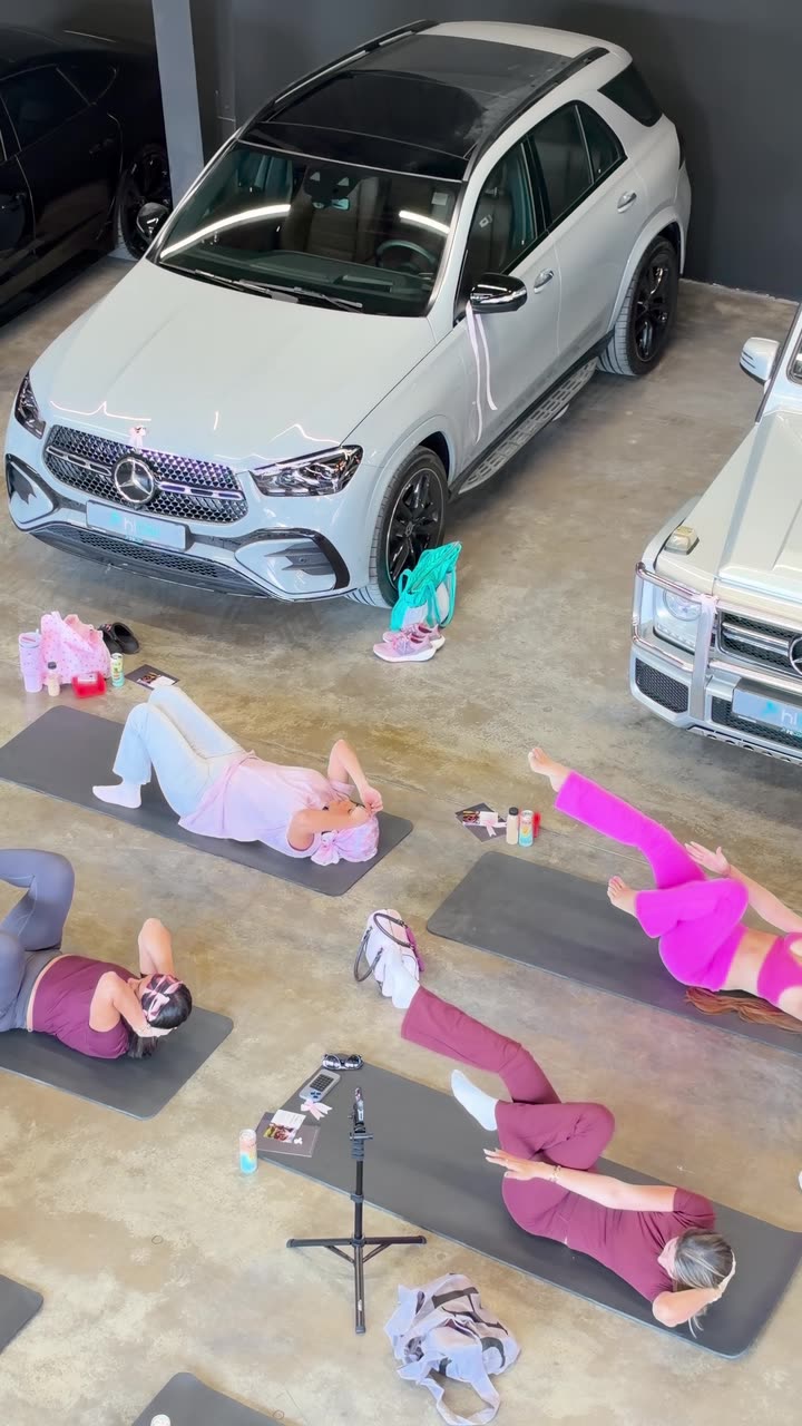 Overhead view of guests on mats between parked luxury cars